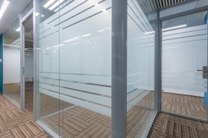 Cubicle office with glass partitions and doors. Floor covering with a beautiful geometric 
pattern.